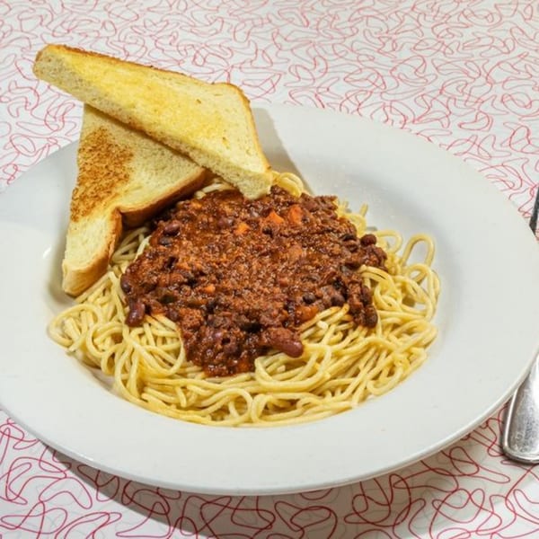 Big Boy's spaghetti with chili and two slices of buttered toast on a white plate.